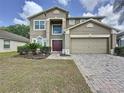 Beautiful two-story home with a two car garage, double front doors, and lush landscaping at 532 Kildrummy Dr, Davenport, FL 33896