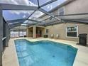 Inviting screened-in pool with a shaded patio area, perfect for enjoying the outdoors and entertaining guests at 532 Kildrummy Dr, Davenport, FL 33896