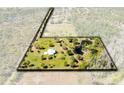 Expansive property with a well-maintained home, lush landscaping, and serene pond with mature trees at 5801 N Kenansville Rd, St Cloud, FL 34773