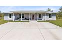 Charming home featuring a concrete driveway, front porch with seating, and well-kept landscaping at 5801 N Kenansville Rd, St Cloud, FL 34773