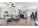 Open-concept living area with hardwood floors, plush sofas, and a modern kitchen island at 5801 N Kenansville Rd, St Cloud, FL 34773