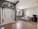 Bright living room features built in bookcases, tile flooring, and front door access at 834 High Pointe Cir, Minneola, FL 34715
