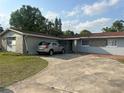 Shows driveway leading to the attached garage with a car parked outside of the modest single-story house at 837 Quintilian Ave, Orlando, FL 32809