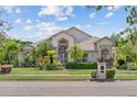 Charming home featuring lush landscaping with tropical plants and a well-maintained green lawn at 8550 Lost Cove Dr, Orlando, FL 32819