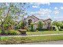 Beautiful property boasts a vibrant landscaped front yard with mature trees and blooming flowers at 8550 Lost Cove Dr, Orlando, FL 32819