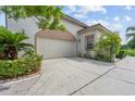 Attached garage with a neutral door, surrounded by greenery and a well-maintained driveway at 8550 Lost Cove Dr, Orlando, FL 32819