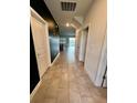 A well-lit hallway with tile flooring leading to a view of the pool at 9122 Sommerset Hills Dr, Davenport, FL 33896