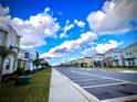 Street view of modern homes, sidewalks, street parking, and lush landscaping on a sunny day at 9122 Sommerset Hills Dr, Davenport, FL 33896