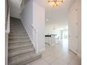 Bright entryway with tiled floors, staircase and adjacent open concept dining and living areas at 10731 Belfry Cir, Orlando, FL 32832