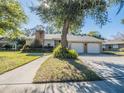 Charming single-Gathering home with a two-car garage and a brick chimney framed by lush landscaping at 1444 Pelican Bay Trl, Winter Park, FL 32792