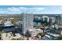 Striking aerial view of a modern high-rise residential building with a rooftop pool overlooking a scenic lake and city at 150 E Robinson St # 219, Orlando, FL 32801