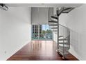 Open living space with hardwood floors, balcony, and spiral staircase at 150 E Robinson St # 219, Orlando, FL 32801