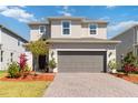 Charming two-story home featuring a well-manicured lawn, paver driveway, and neutral color palette at 1565 Leaf Ln, Kissimmee, FL 34744
