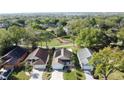 Aerial view showcases the homes in a neighborhood, surrounded by lush greenery and mature trees near a golf course at 2316 Paulette Dr, Haines City, FL 33844