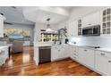 Modern white kitchen featuring stainless steel appliances, sleek countertops, and a herringbone backsplash at 2515 Ridgewind Way, Windermere, FL 34786
