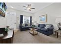 Inviting living room showcasing modern decor, plush blue sofas, and a mounted television for entertainment at 2604 Lodi Cir # 103, Kissimmee, FL 34746