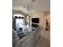 Bright living room showcasing tiled floors, a large sectional sofa, and sliding glass doors to the patio at 2678 Autumn Creek Cir, Kissimmee, FL 34747