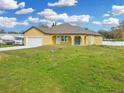Cheerful yellow home featuring an attached one-car garage and a concrete driveway at 2776 Tropical Lake Dr, Kissimmee, FL 34741
