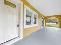 Covered porch with white door, trim and arched detailing leading to the main entrance at 2776 Tropical Lake Dr, Kissimmee, FL 34741