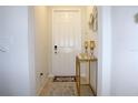 Bright foyer with a white front door, a decorative table, and tile flooring at 2909 Theme St, Kissimmee, FL 34746