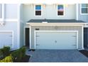 View of the garage and entry of the home with a well-manicured front yard at 2909 Theme St, Kissimmee, FL 34746