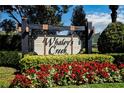 The Whaley's Creek community sign is surrounded by colorful flowers and lush greenery at 3848 Cabo Rojo Dr, St Cloud, FL 34772