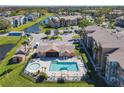 Aerial view of community pool with clubhouse, spa, lounge seating and parking spaces at 4105 Tropical Isle Blvd # 222, Kissimmee, FL 34741
