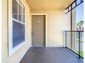 Condo balcony featuring a tan door and siding with a black railing at 4105 Tropical Isle Blvd # 222, Kissimmee, FL 34741