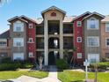 Multi-story condo building featuring colorful facades and a well-maintained green lawn at 4105 Tropical Isle Blvd # 222, Kissimmee, FL 34741