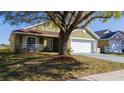Attractive single-story home with a well-manicured lawn, front porch and attached garage at 4419 Great Harbor Ln, Kissimmee, FL 34746