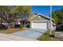 This home has an attached garage, front porch and mature landscaping at 4419 Great Harbor Ln, Kissimmee, FL 34746