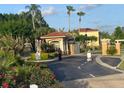 Community entrance with palm trees, lush landscaping, and controlled access at 4726 Ormond Beach Way, Kissimmee, FL 34746