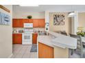 Well-lit kitchen featuring white appliances, tiled floors and plenty of cabinet space at 4726 Ormond Beach Way, Kissimmee, FL 34746