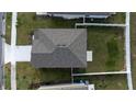 Aerial view of the house showcasing its roof, driveway, and a well-maintained lawn at 606 Bell Prairie Cir, Lake Wales, FL 33859