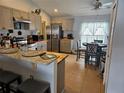 Bright eat-in kitchen with stainless steel appliances, light gray cabinets, and breakfast bar at 633 Kangaroo Dr, Kissimmee, FL 34759