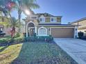 Charming two-story home with lush landscaping, a driveway, and a two-car garage at 802 Suffolk Pl, Davenport, FL 33896