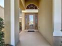 Beautiful front door with decorative glass and sidelights, sheltered beneath a covered porch at 802 Suffolk Pl, Davenport, FL 33896