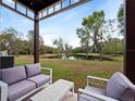 Relaxing backyard patio view showcasing outdoor seating and serene lake landscape, perfect for enjoying nature at 8517 Crystal Cove Loop, Kissimmee, FL 34747