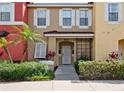 A close up shot of townhome exterior with white trim, decorative shrubs, and a walkway to the entrance at 8517 Crystal Cove Loop, Kissimmee, FL 34747