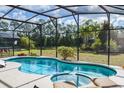 Screened-in pool and jacuzzi with a private backyard view and sunny skies at 917 Orange Cosmos Blvd, Davenport, FL 33837