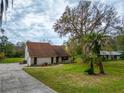 Spacious home featuring a long driveway, mature trees, and a lush green lawn at 9916 Jackson Rd, Leesburg, FL 34788