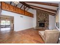 Inviting living room with stone fireplace, vaulted ceilings, and wood-look floors at 9916 Jackson Rd, Leesburg, FL 34788
