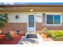 Inviting entryway with a decorated door, brick accents, and manicured garden at 1518 Mississippi Ave, St Cloud, FL 34769