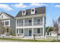Inviting two-story home featuring double porches and a well-maintained lawn, exuding classic charm at 205 Norfolk Pl, Celebration, FL 34747