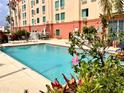 Beautiful outdoor swimming pool with lounge chairs and tropical plants for a relaxing vacation at 3000 Maingate Ln # 330, Kissimmee, FL 34747
