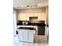 Updated kitchen with black countertops, white cabinets, and stainless steel appliances at 414 Dakota Ave, St Cloud, FL 34769