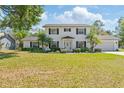 Charming two-story home with a well-manicured lawn, mature landscaping, and a classic white exterior at 4531 Lake Trudy Dr, St Cloud, FL 34769