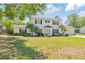 Charming two-story home with a well-manicured lawn, mature landscaping, and a classic white exterior at 4531 Lake Trudy Dr, St Cloud, FL 34769