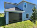 View of the rear of the home showing the screened-in lanai and green lawn at 474 Annabelle Way, Davenport, FL 33837