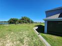 Large backyard with lush lawn, partially fenced, backing up to community pond at 474 Annabelle Way, Davenport, FL 33837